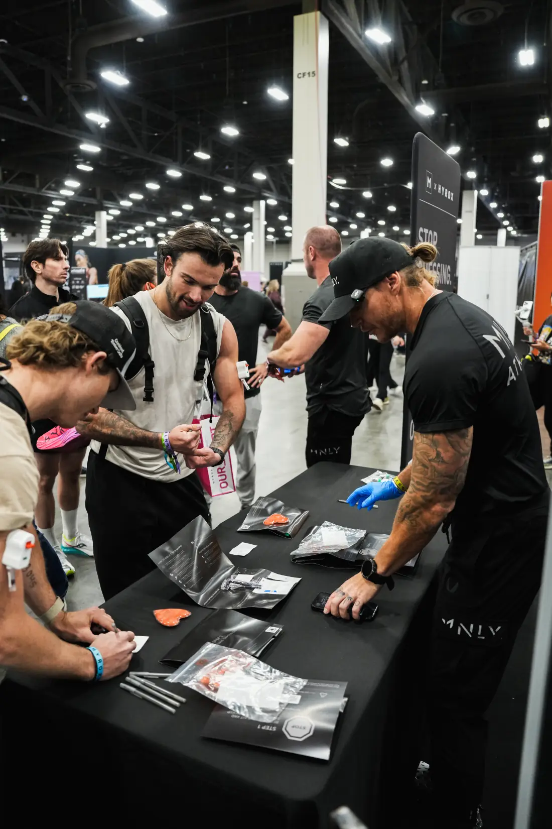 Athletes gathered at the MNLY booth counter